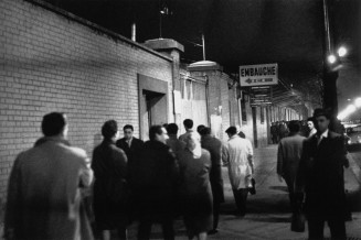 Photographie de Gérald Bloncourt. Scène représentant la file d'hommes pour l'embauche à l'usine Citroën de Paris