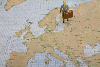 Figurine avec une valise sur un planisphère