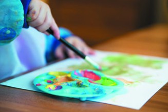 Photographie d'un atelier, plan rapproché d'un pinceau et d'une palette de peinture