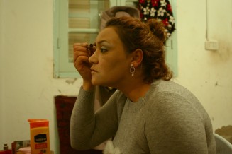 Femme qui se maquille devant un miroir